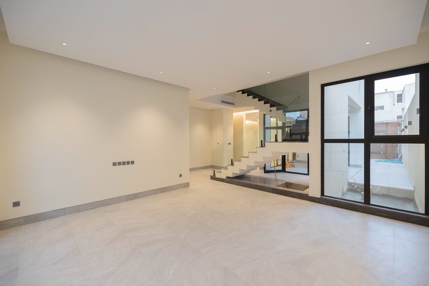 Spacious living area with an internal staircase and glass facade